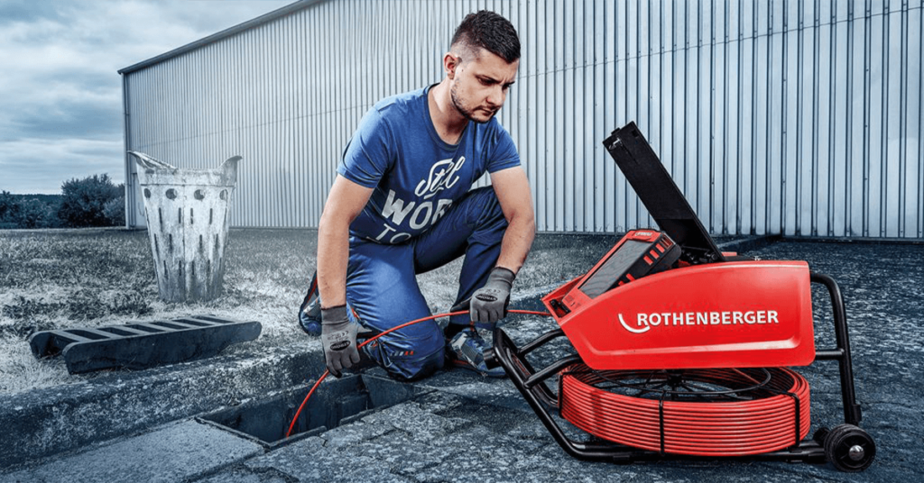 A plumber views real-time drain camera footage on a monitor. The high-resolution video feed is recorded to create a precise video report of your pipes.